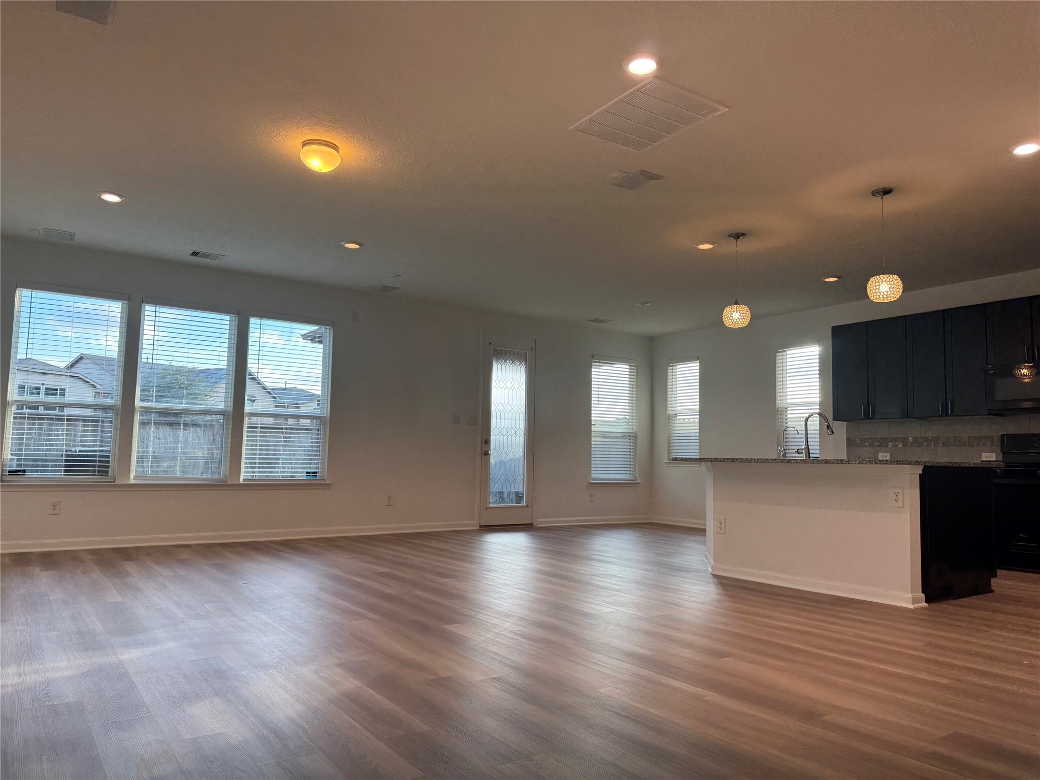 15815 Copper Oak Lane Houston, TX 77084 - Photo 11 of 33 a view of an empty room with wooden floor and a kitchen