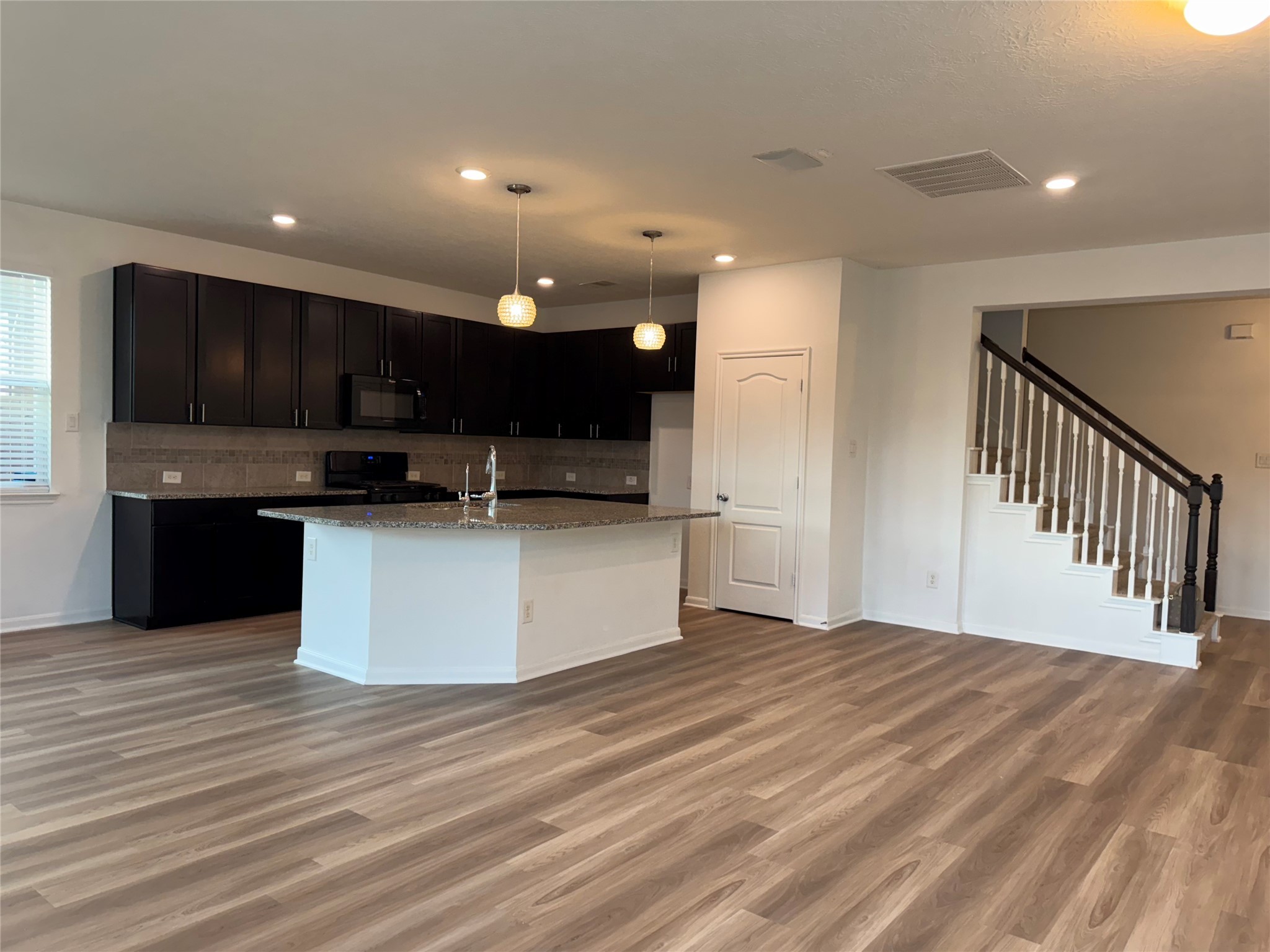 15815 Copper Oak Lane Houston, TX 77084 - Photo 12 of 33 a view of kitchen with kitchen island a sink wooden floor and a refrigerator
