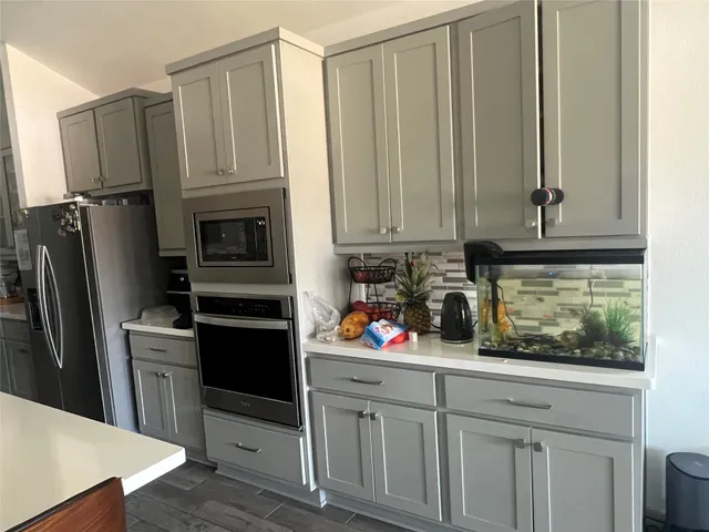 a kitchen with stainless steel appliances white cabinets and a refrigerator