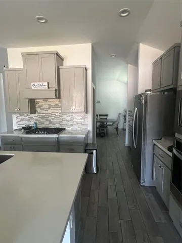 a kitchen with stainless steel appliances granite countertop a refrigerator a stove and a sink