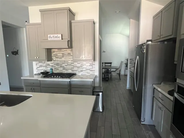 a kitchen with stainless steel appliances granite countertop a refrigerator a stove and a sink