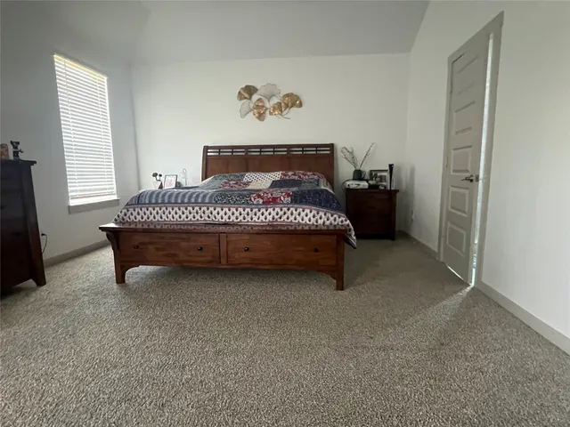 a spacious bedroom with a bed and a window