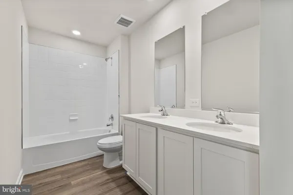 a bathroom with a double vanity sink toilet and shower