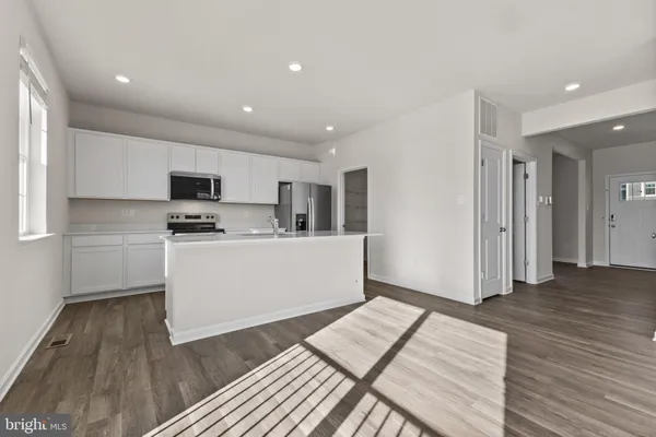 a kitchen with stainless steel appliances a refrigerator sink and microwave