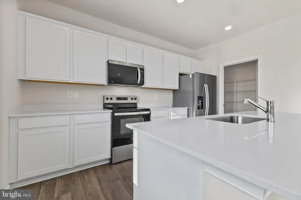 a kitchen with stainless steel appliances a refrigerator sink and microwave