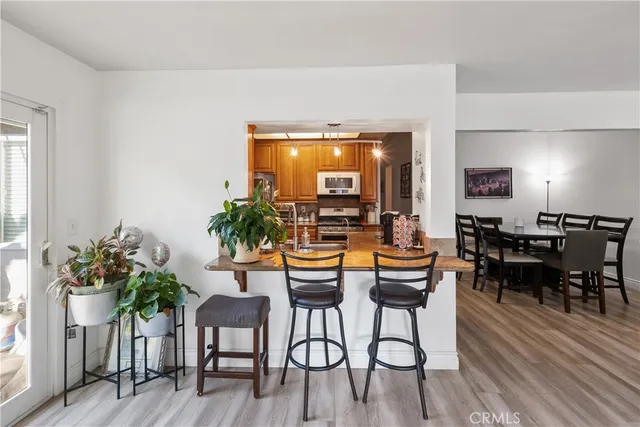 a dining room with furniture potted plants and wooden floor