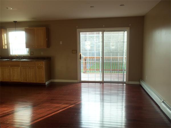 85 Baird Street Fall River, MA 02721 - Photo 3 of 8 a view of an empty room with wooden floor and a window