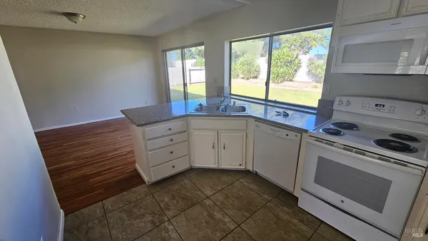 a kitchen with cabinets appliances and a window