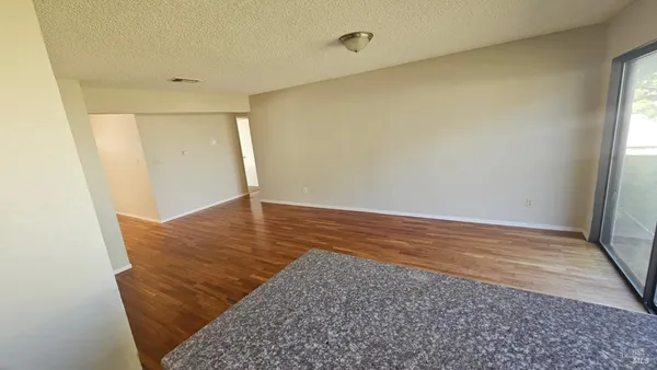an empty room with wooden floor and window