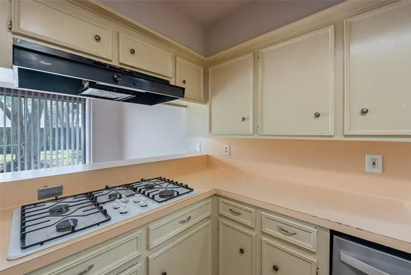 a kitchen with white cabinets and sink