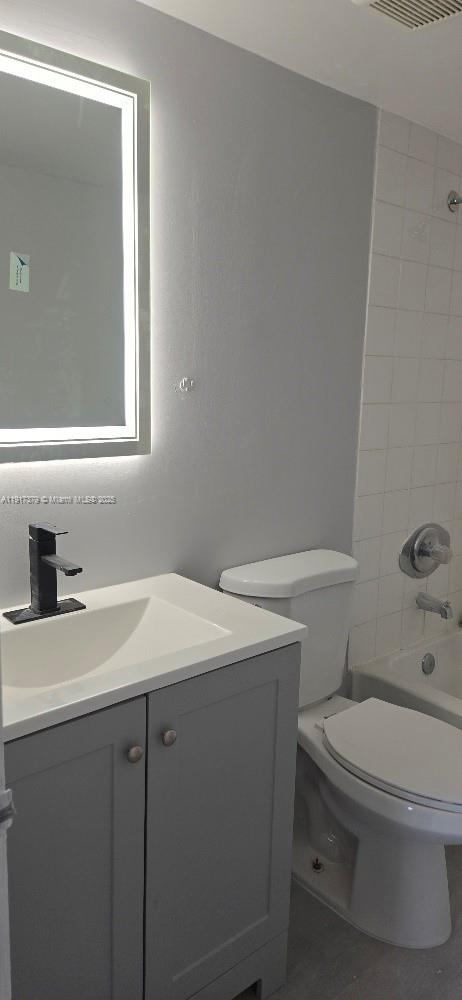 8145 Northwest 7th Street, Unit 320 Miami, FL 33126 - Photo 7 of 9 a bathroom with a toilet sink vanity and mirror