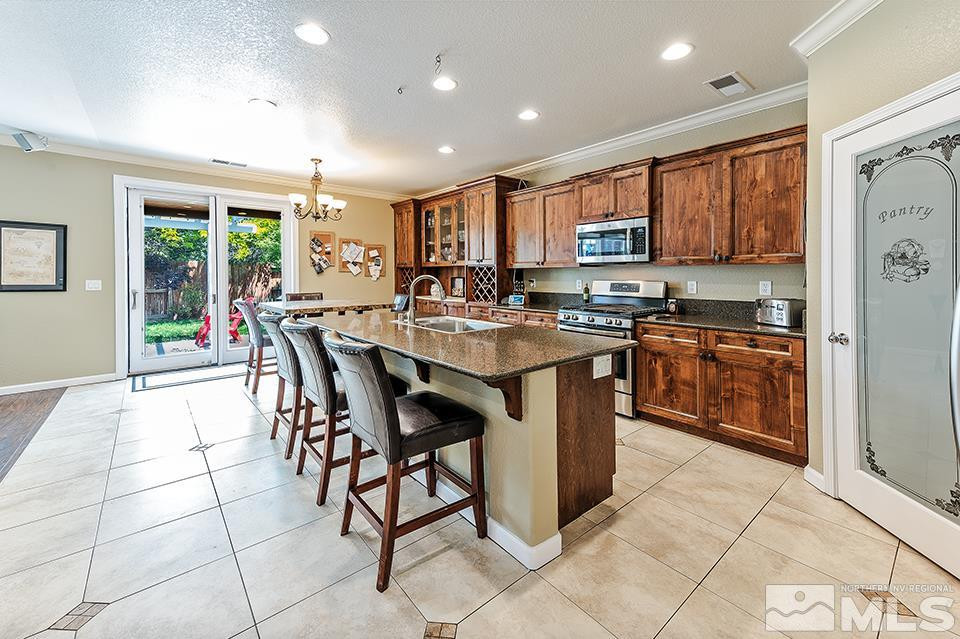 1783 Back Country Road Reno, NV 89521 - Photo 3 of 16 a kitchen with stainless steel appliances granite countertop a stove a sink a oven a dining table and chairs