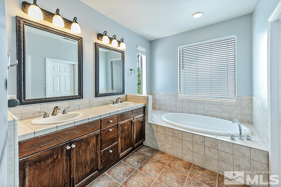 1783 Back Country Road Reno, NV 89521 - Photo 10 of 16 a spacious bathroom with a double vanity sink large mirror and a bathtub