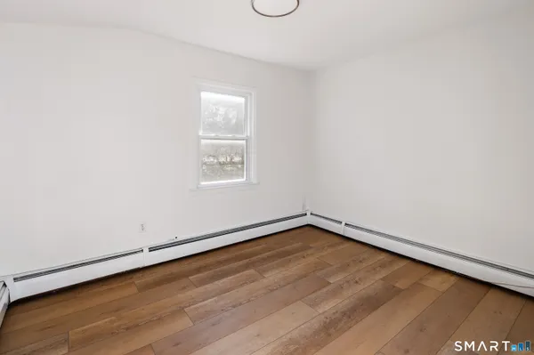 a view of a room with wooden floor and window