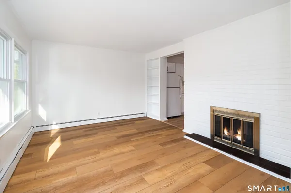 a view of an empty room with a fireplace and a window