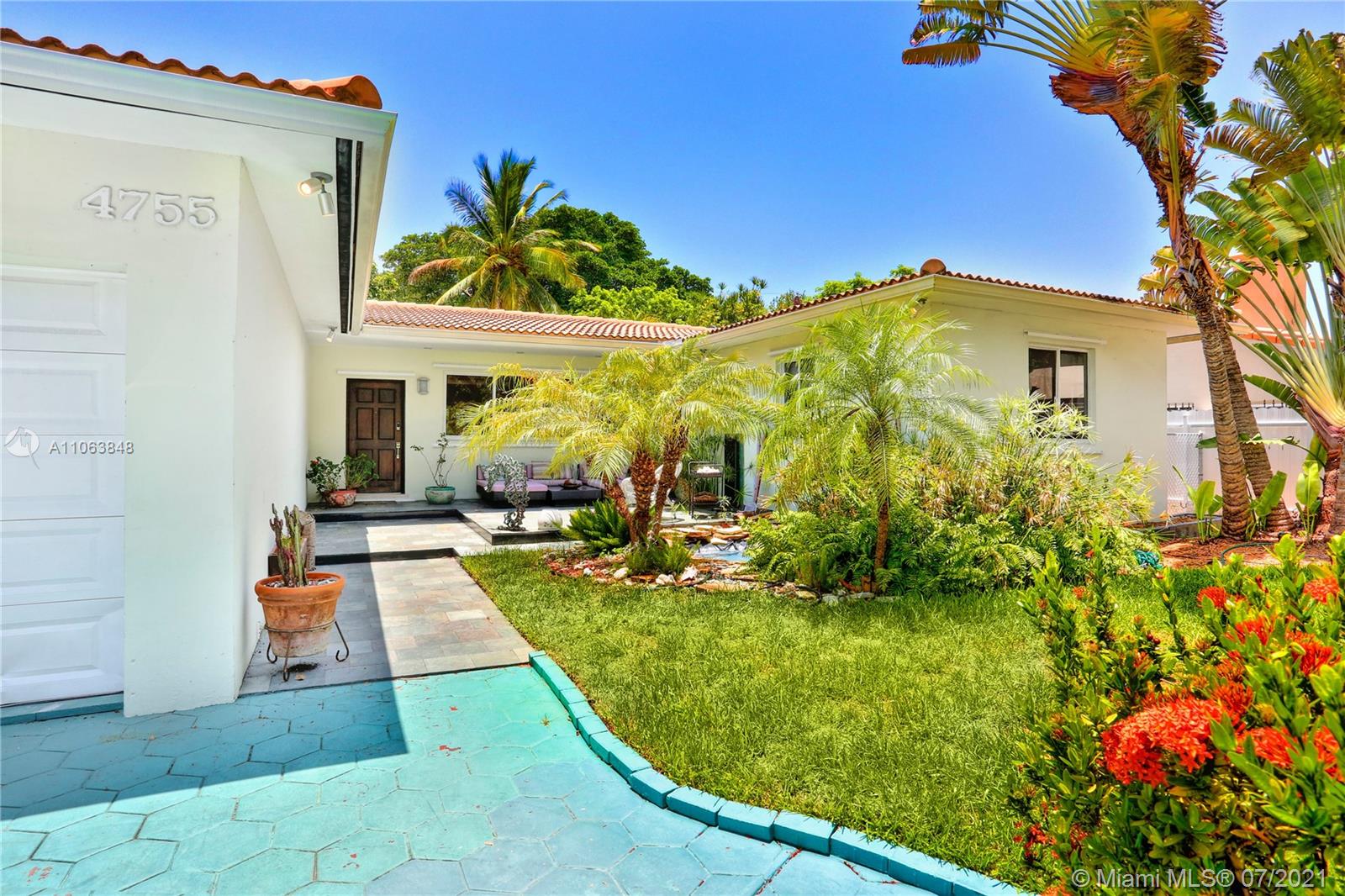 4755 Alton Road Miami Beach, FL 33140 - Photo 2 of 21 a view of a house with swimming pool and a yard