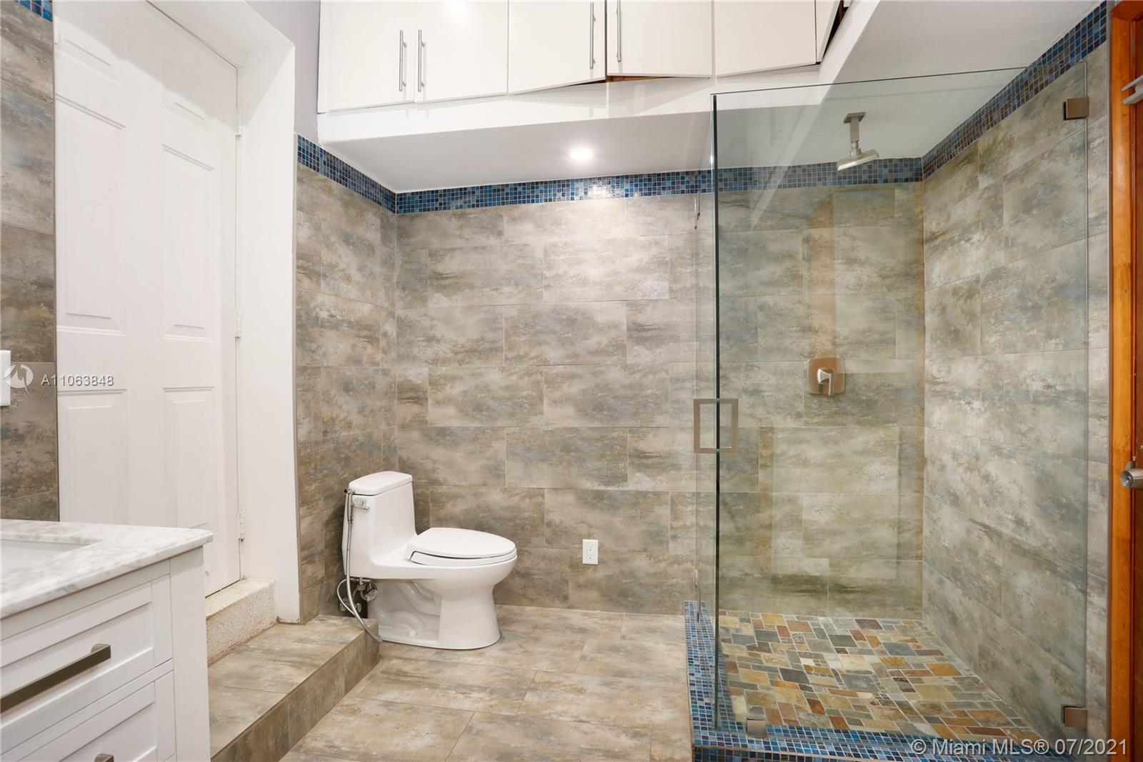 4755 Alton Road Miami Beach, FL 33140 - Photo 15 of 21 a bathroom with a granite countertop shower a toilet and a sink
