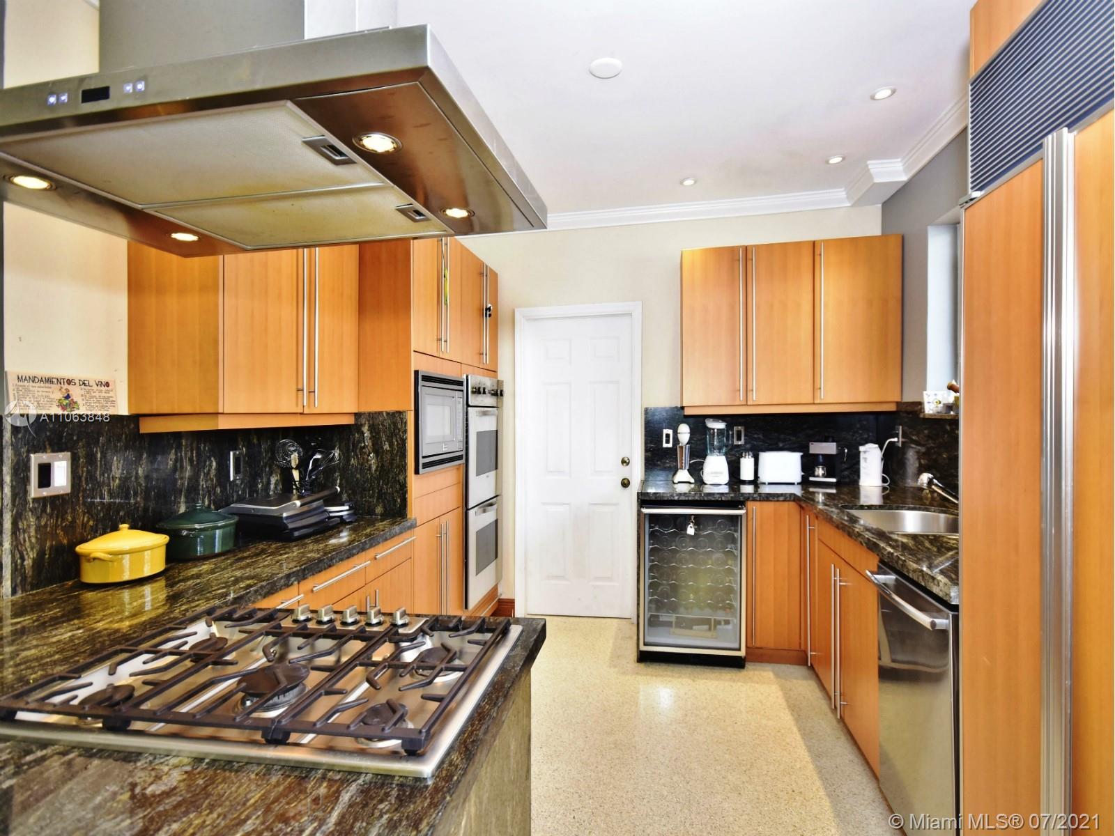 4755 Alton Road Miami Beach, FL 33140 - Photo 7 of 21 a kitchen with stainless steel appliances granite countertop a stove a sink and a refrigerator