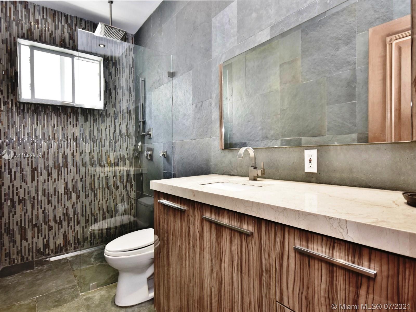 4755 Alton Road Miami Beach, FL 33140 - Photo 10 of 21 a bathroom with a sink a toilet and shower