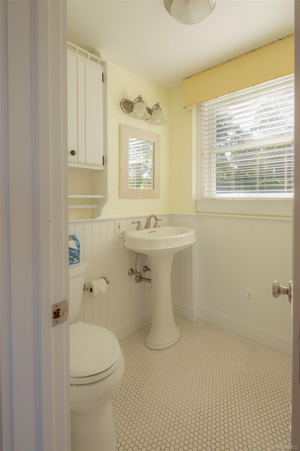 1 Canal Road Hampton Bays, NY 11946 - Photo 20 of 50 Half bathroom featuring plenty of natural light and a wainscoted wall
