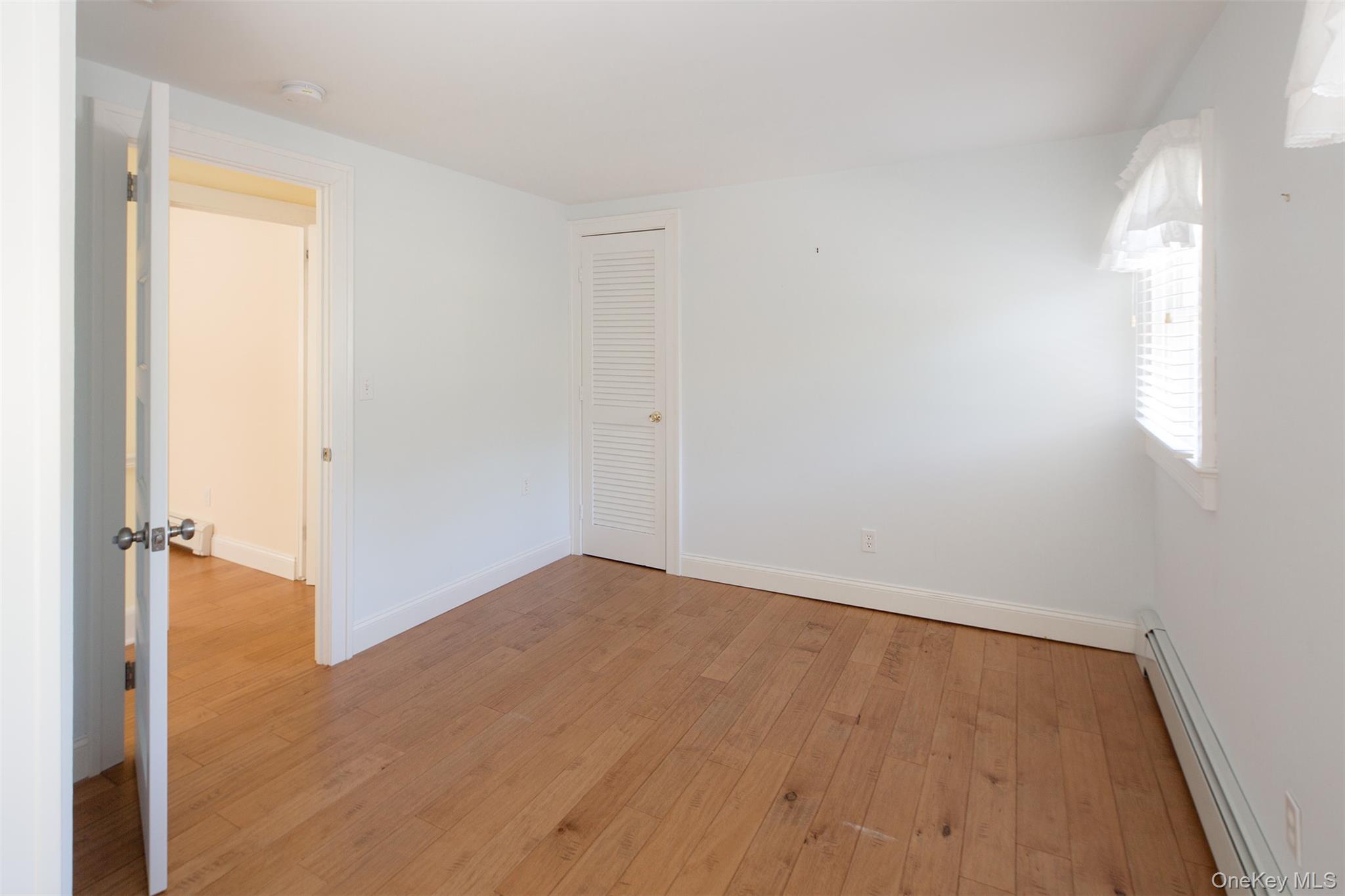1 Canal Road Hampton Bays, NY 11946 - Photo 21 of 50 Unfurnished room featuring baseboard heating and light wood-type flooring