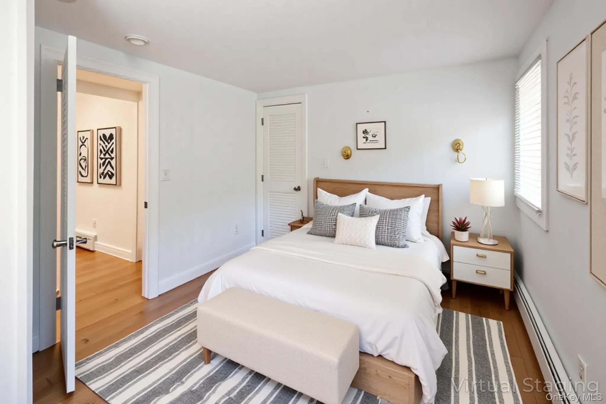1 Canal Road Hampton Bays, NY 11946 - Photo 22 of 50 Virtually Staged Bedroom featuring a baseboard heating unit, wood finished floors, a closet, and baseboard heating