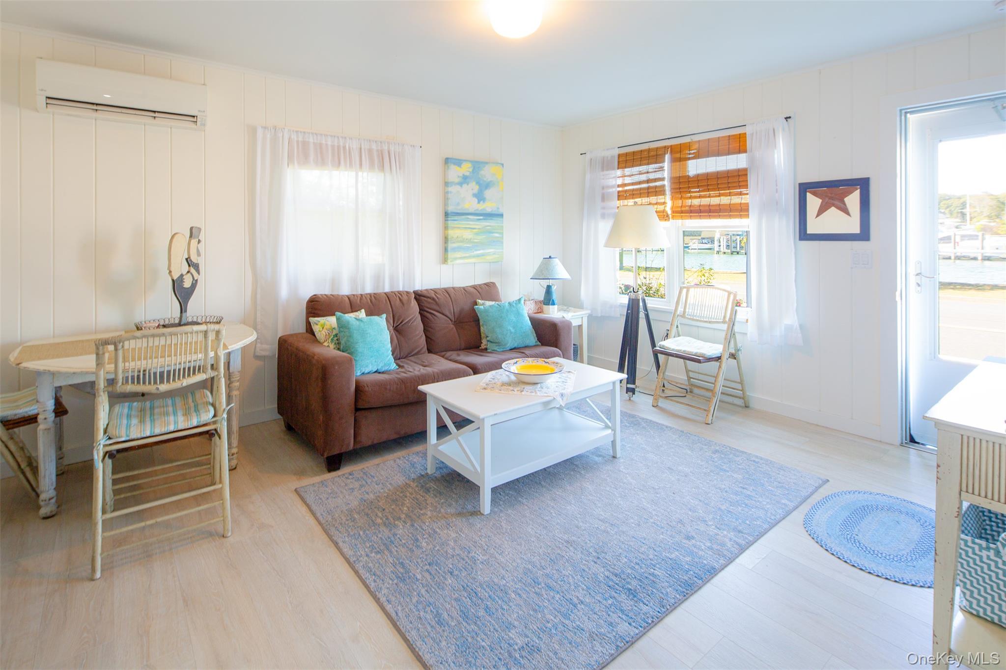 1 Canal Road Hampton Bays, NY 11946 - Photo 46 of 50 Living room with healthy amount of natural light, light wood-style flooring, and a wall mounted air conditioner