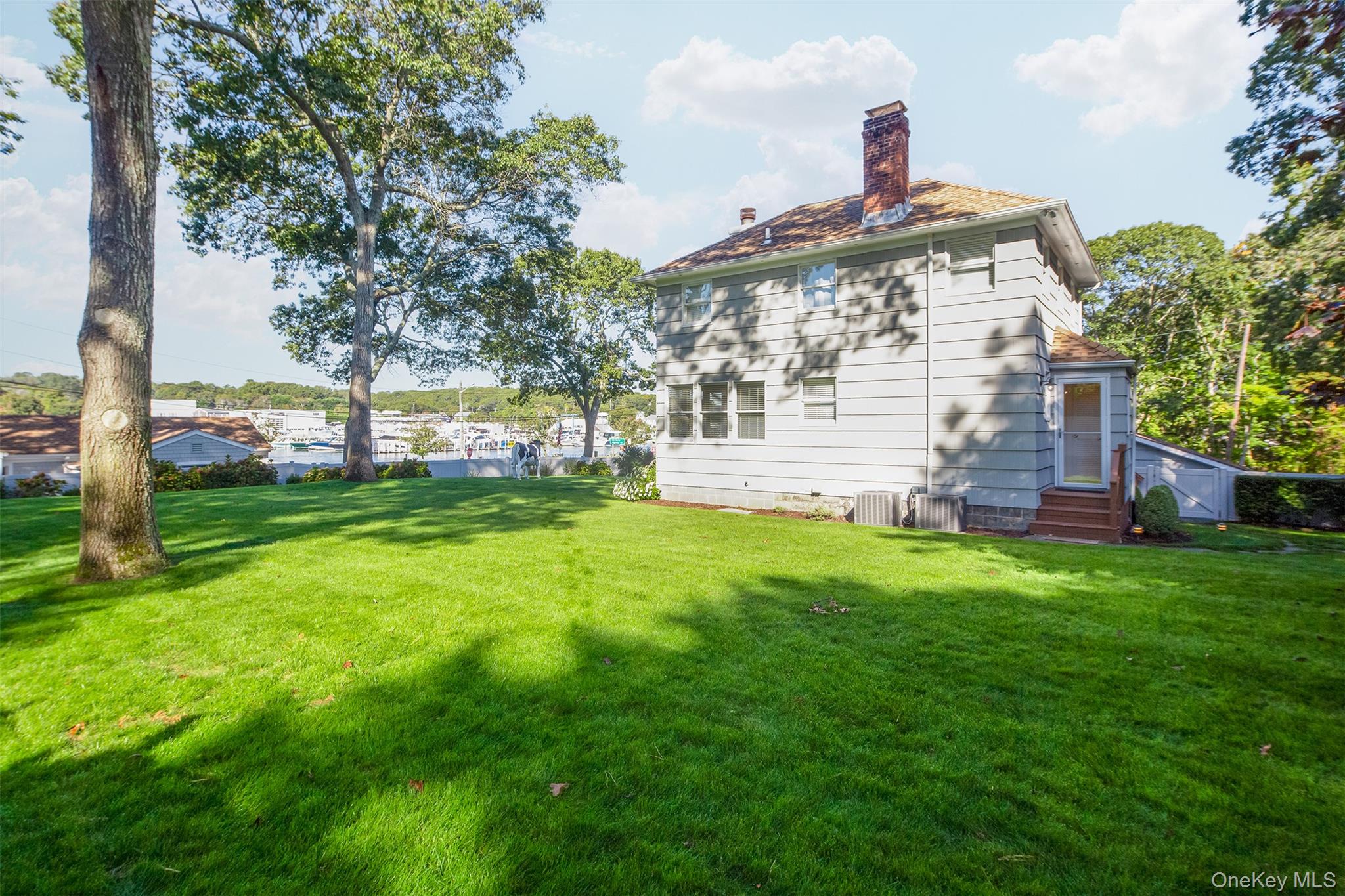 1 Canal Road Hampton Bays, NY 11946 - Photo 5 of 50 Back of house with a chimney, a yard, and entry steps