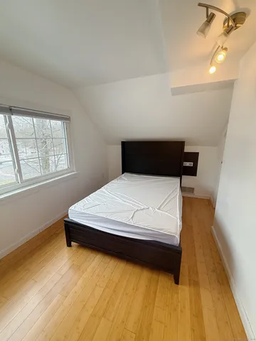 a bed sitting in a bedroom next to a window