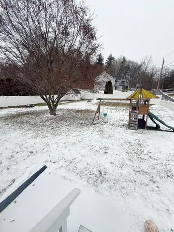a view of a dry yard with wooden fence