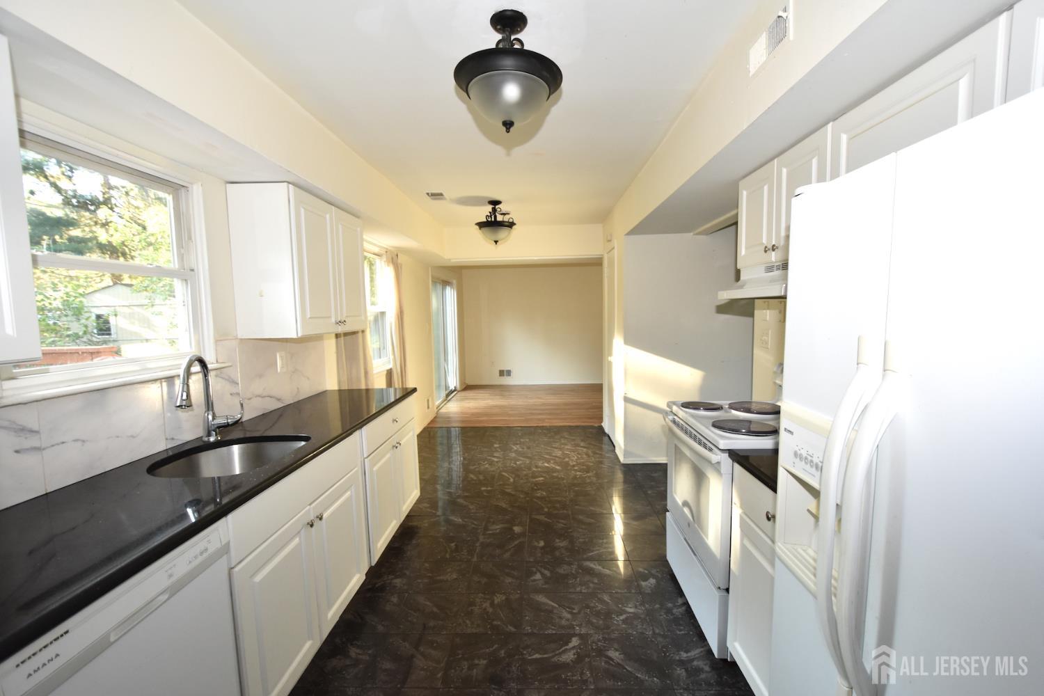 8 Wethersfield Road Plainsboro, NJ 08536 - Photo 7 of 28 a view of a kitchen with a sink and dishwasher with wooden floor