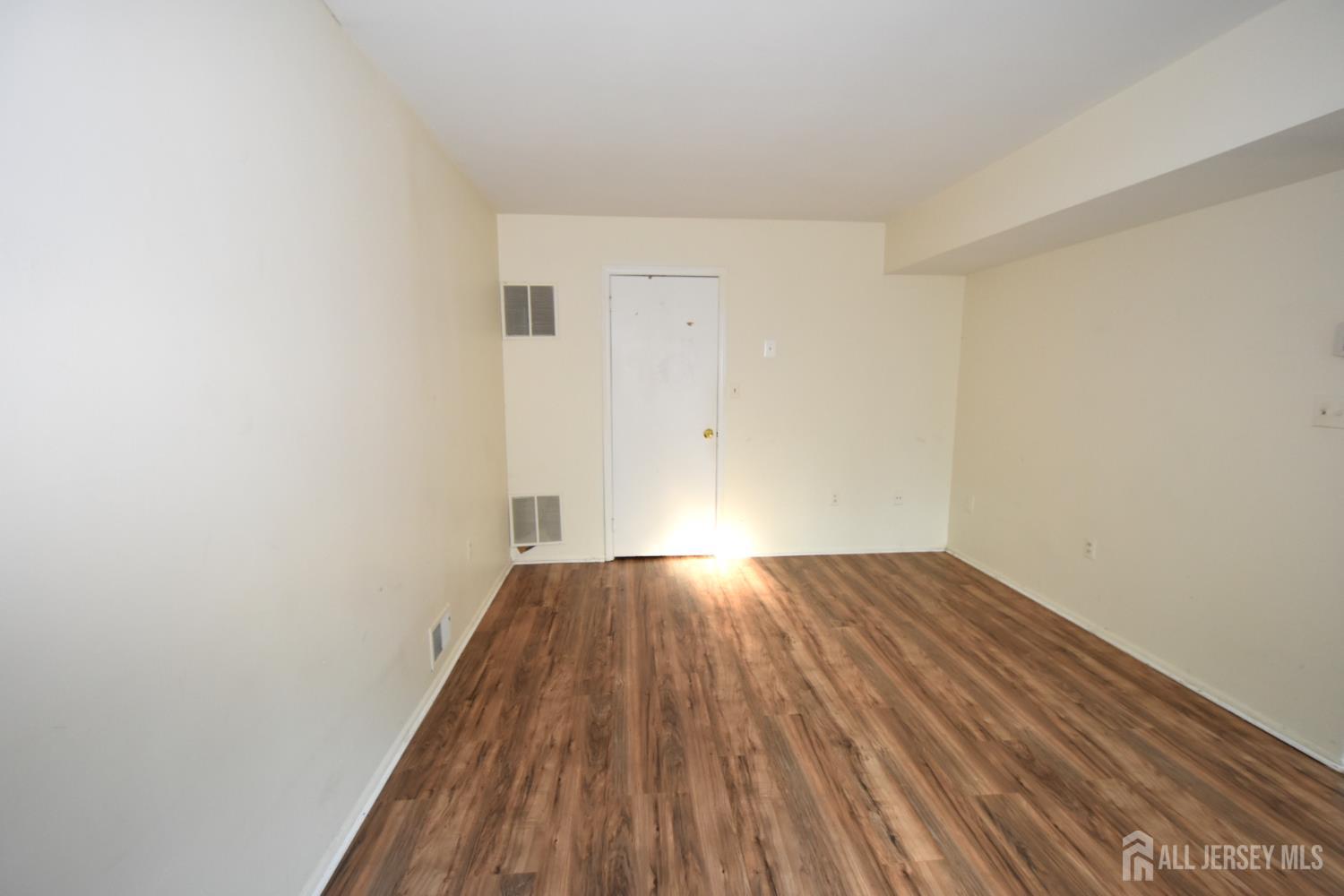 8 Wethersfield Road Plainsboro, NJ 08536 - Photo 10 of 28 a view of an empty room with wooden floor and a window