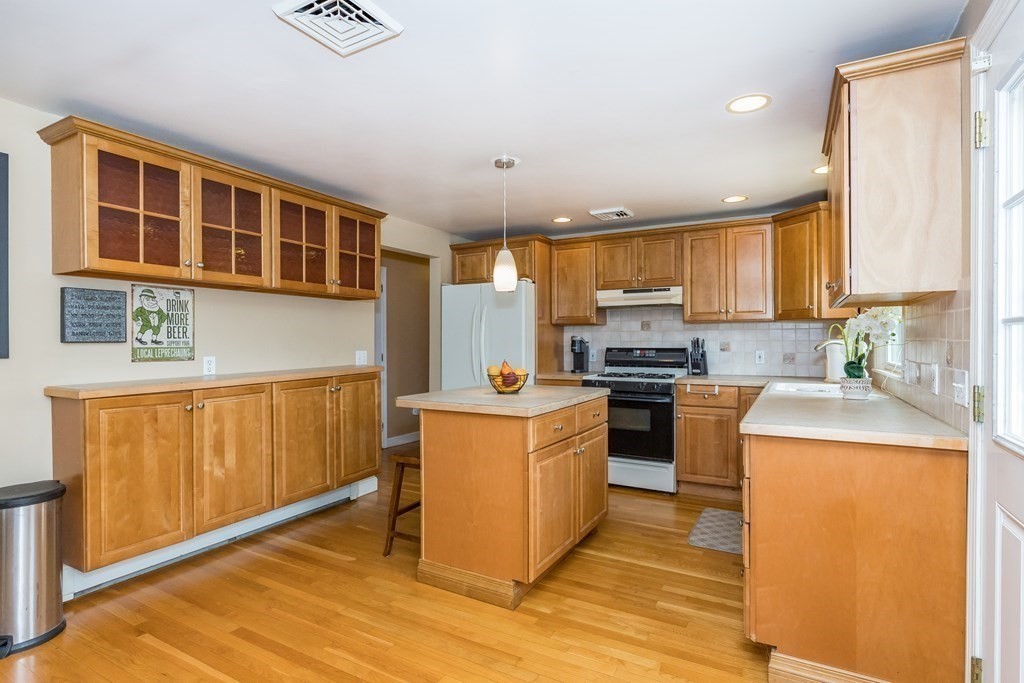 2 Marilyn Road Billerica, MA 01821 - Photo 5 of 32 a kitchen with stainless steel appliances granite countertop a stove top oven a refrigerator a sink and dishwasher with wooden cabinets