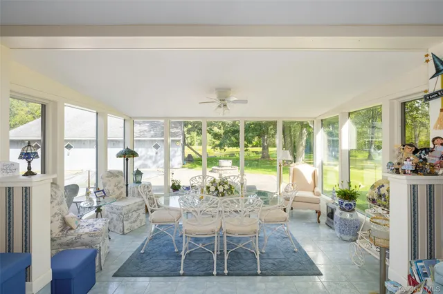a living room with furniture large window and wooden floor