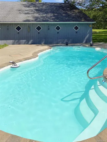 a swimming pool with trees in front of it