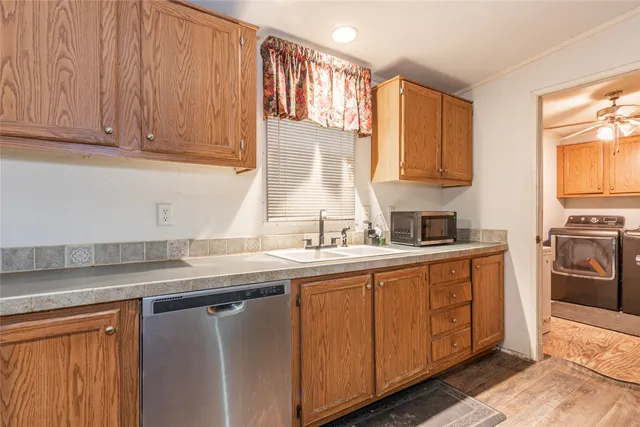 a kitchen with stainless steel appliances granite countertop a sink a stove and a refrigerator