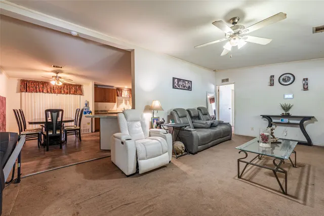 a living room with furniture and view of kitchen