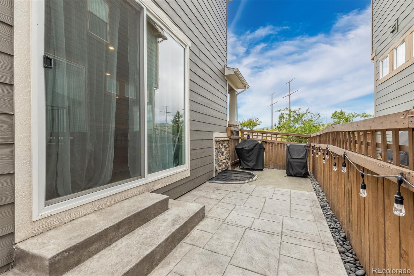 7199 Othello Street Castle Pines, CO 80108 - Photo 20 of 28 a view of a balcony with chairs and wooden fence