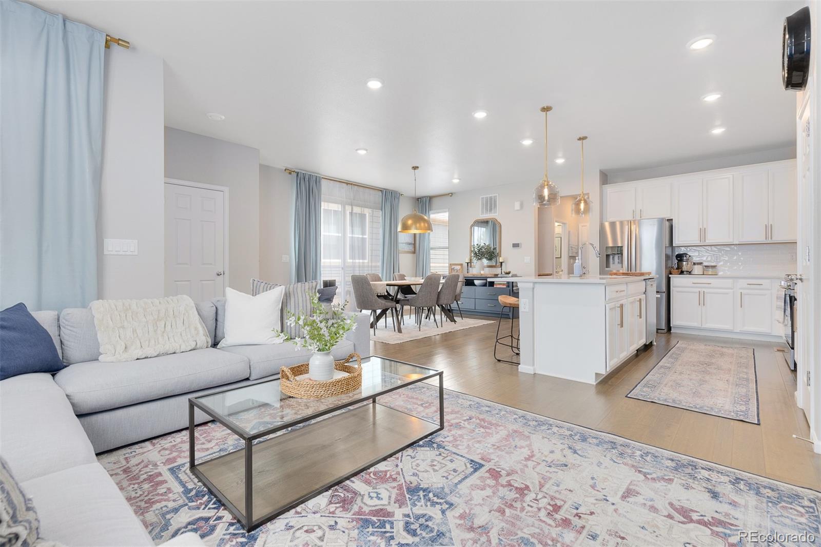 7199 Othello Street Castle Pines, CO 80108 - Photo 2 of 28 a living room with furniture and a dining table with kitchen view