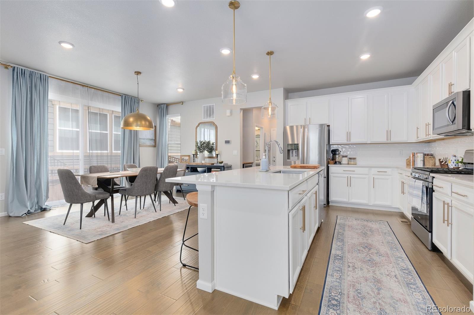7199 Othello Street Castle Pines, CO 80108 - Photo 3 of 28 a kitchen with counter top space a sink appliances and cabinets