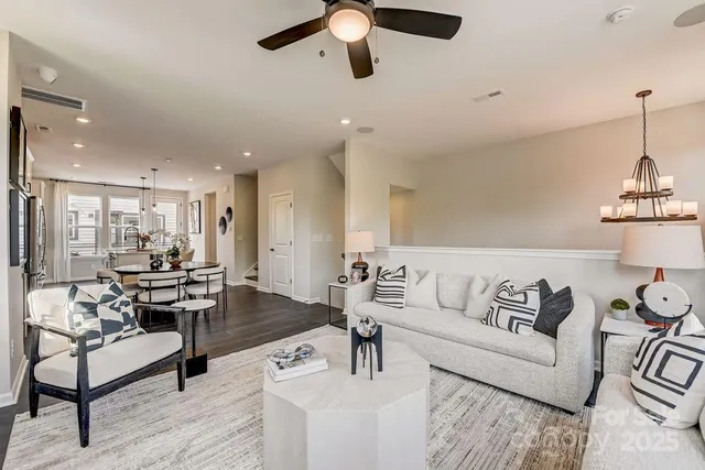 a kitchen with stainless steel appliances granite countertop a dining table chairs and white cabinets