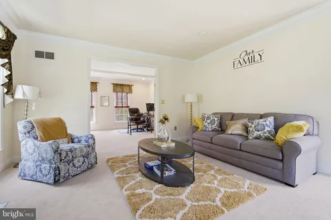 a living room with furniture a flat screen tv and a window
