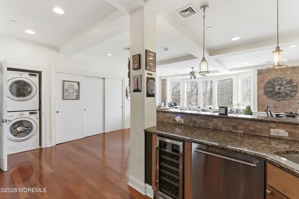 a open kitchen with stainless steel appliances granite countertop a sink a stove and a wooden floors