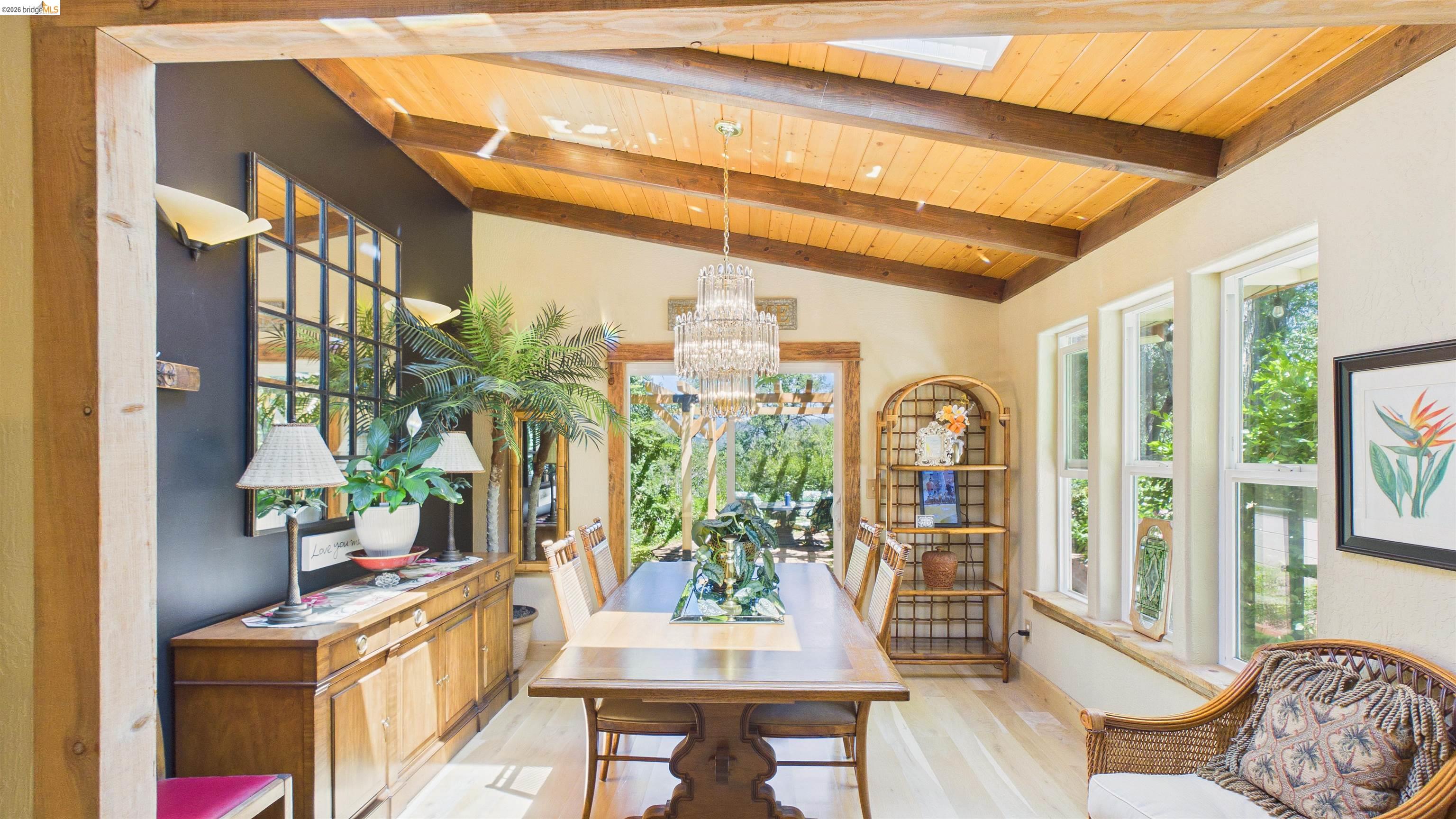 18102 Mt Eaton Road Tuolumne, CA 95379 - Photo 6 of 44 Dining space featuring a wood-finish vaulted ceiling with exposed beams, light wood-finish flooring, and multiple vertical windows