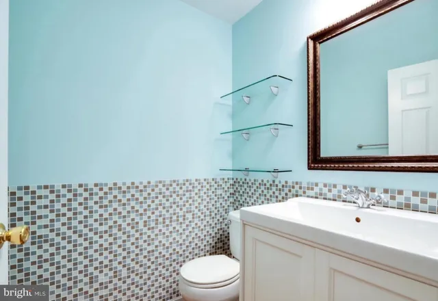 a bathroom with a sink a toilet and mirror