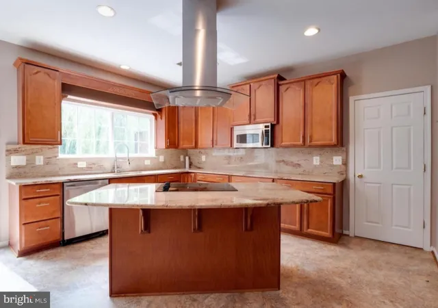 a kitchen with stainless steel appliances granite countertop a sink a stove and a wooden floors
