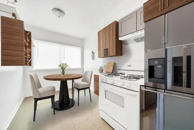 a kitchen with a stove a table and chairs in it