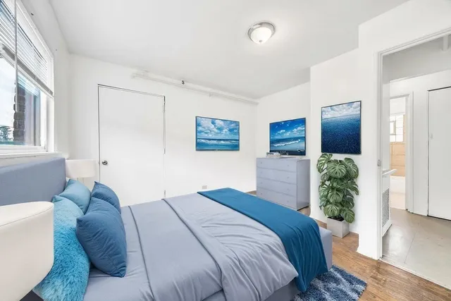 a bedroom with a large bed and windows