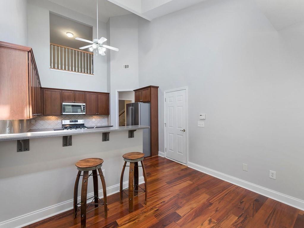 820 Freedom Lane Roswell, GA 30075 - Photo 12 of 30 a kitchen with stainless steel appliances a dining table chairs cabinets and wooden floor