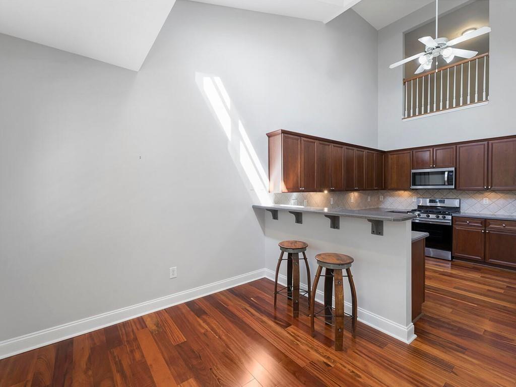 820 Freedom Lane Roswell, GA 30075 - Photo 14 of 30 a kitchen with stainless steel appliances granite countertop a stove a sink dishwasher and a microwave with wooden floor
